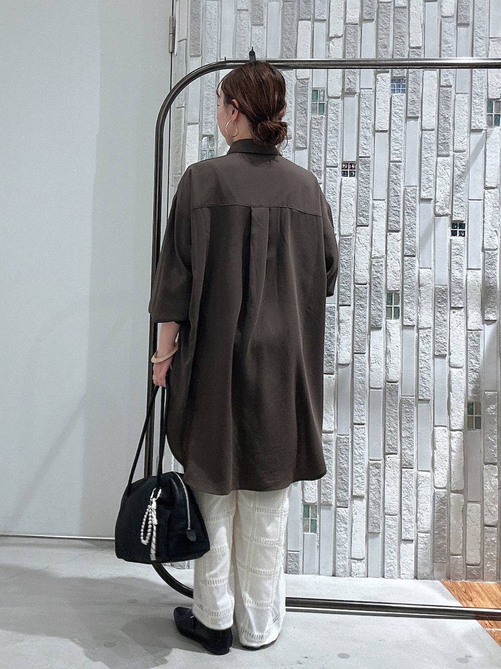 ブラウン系のシャツ/ブラウス、ブラック系のボストンバッグ、ホワイト系のその他パンツを着用したレディースの冬コーディネートの4枚目の写真