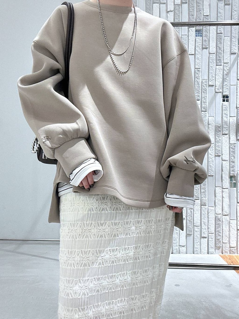 ブラック系のサンダル、ブラウン系のボストンバッグ、ブラウン系のスウェットを着用したレディースの冬コーディネートの5枚目の写真