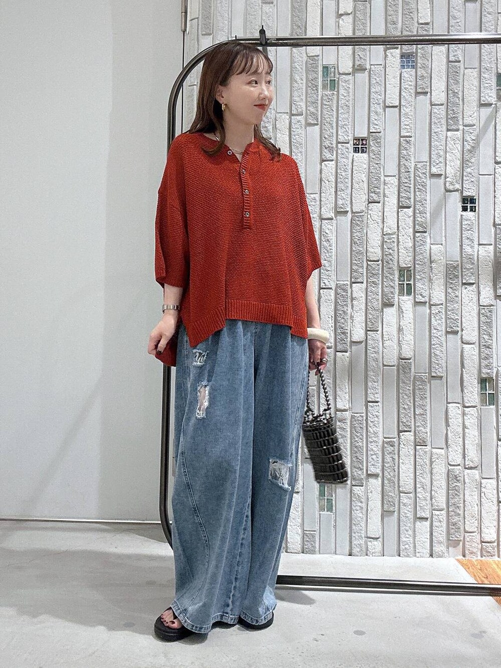 ブラウン系のサンダル、シルバー系のショルダーバッグ、ブルー系のデニムパンツを着用したレディースの夏コーディネートの2枚目の写真