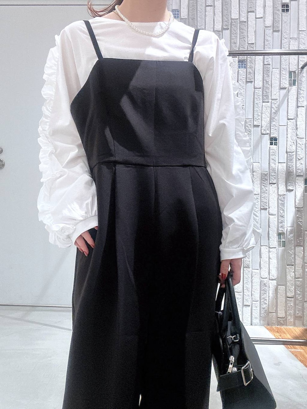 ブラック系のサロペット/オーバーオール、ホワイト系のTシャツ/カットソー、ブラック系のショルダーバッグを着用したレディースの冬コーディネートの8枚目の写真