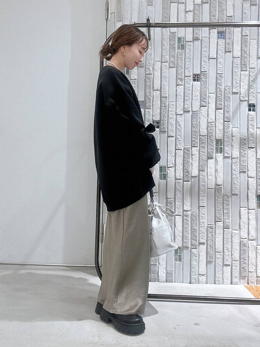 グリーン系のスカート、ブラック系のスウェット、ホワイト系のTシャツ/カットソーを着用したレディースの冬コーディネートの3枚目の写真