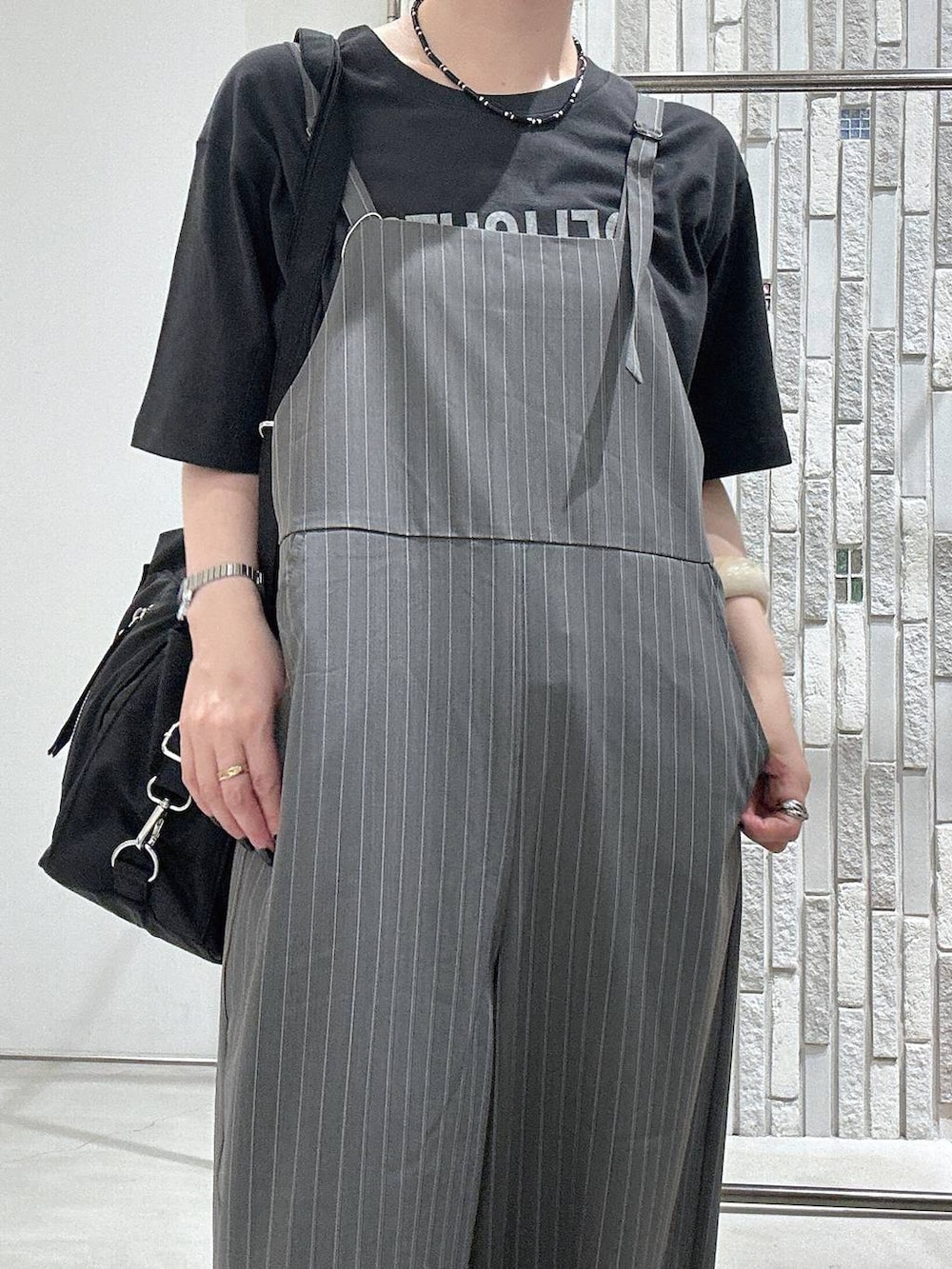 グレー系のサロペット/オーバーオール、グレー系のTシャツ/カットソー、ブラック系のショルダーバッグを着用したレディースの夏コーディネートの5枚目の写真