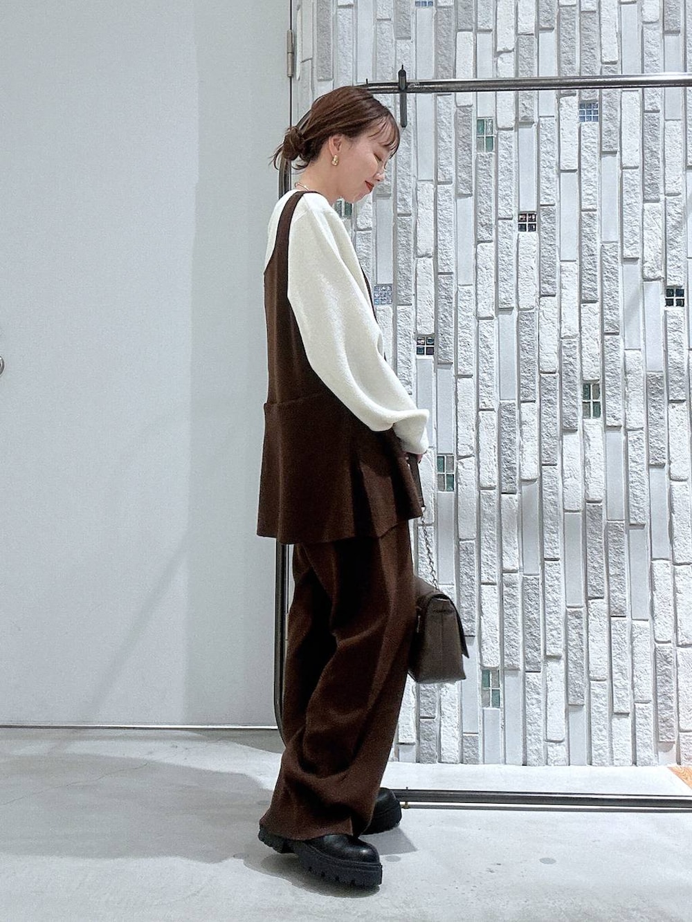 ブラック系のブーツ、ホワイト系のTシャツ/カットソー、ブラウン系のショルダーバッグを着用したレディースの冬コーディネートの4枚目の写真