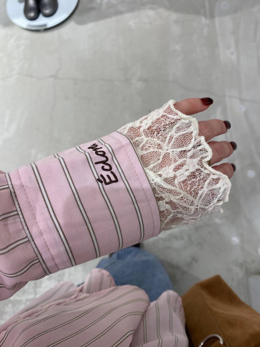 ブラウン系のショルダーバッグ、ブラウン系のサンダル、ブルー系のデニムパンツを着用したレディースの冬コーディネートの6枚目の写真