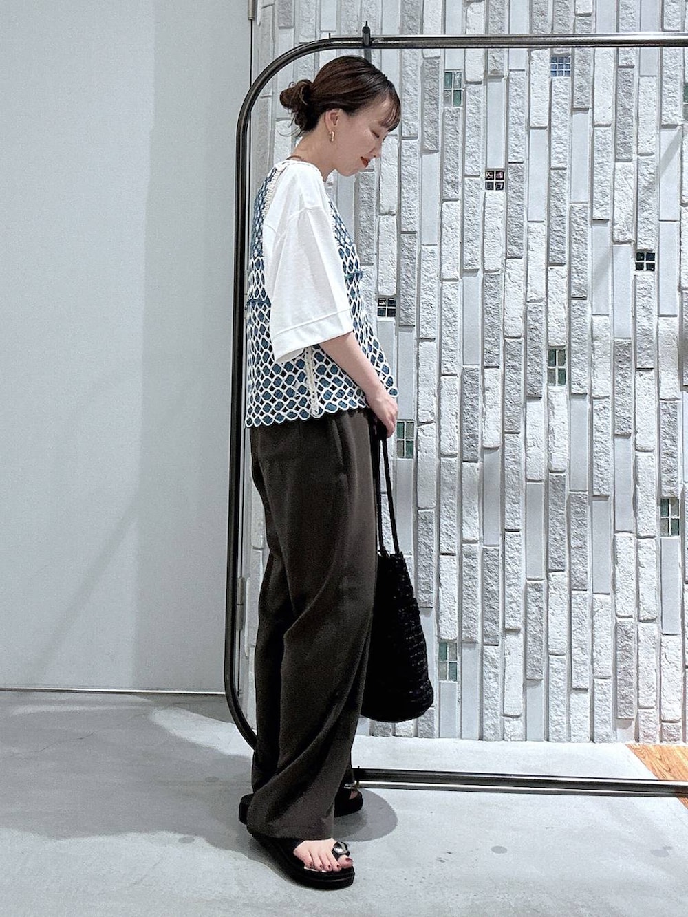 ブラウン系のその他パンツ、ブラック系のサンダル、ホワイト系のTシャツ/カットソーを着用したレディースの春コーディネートの3枚目の写真