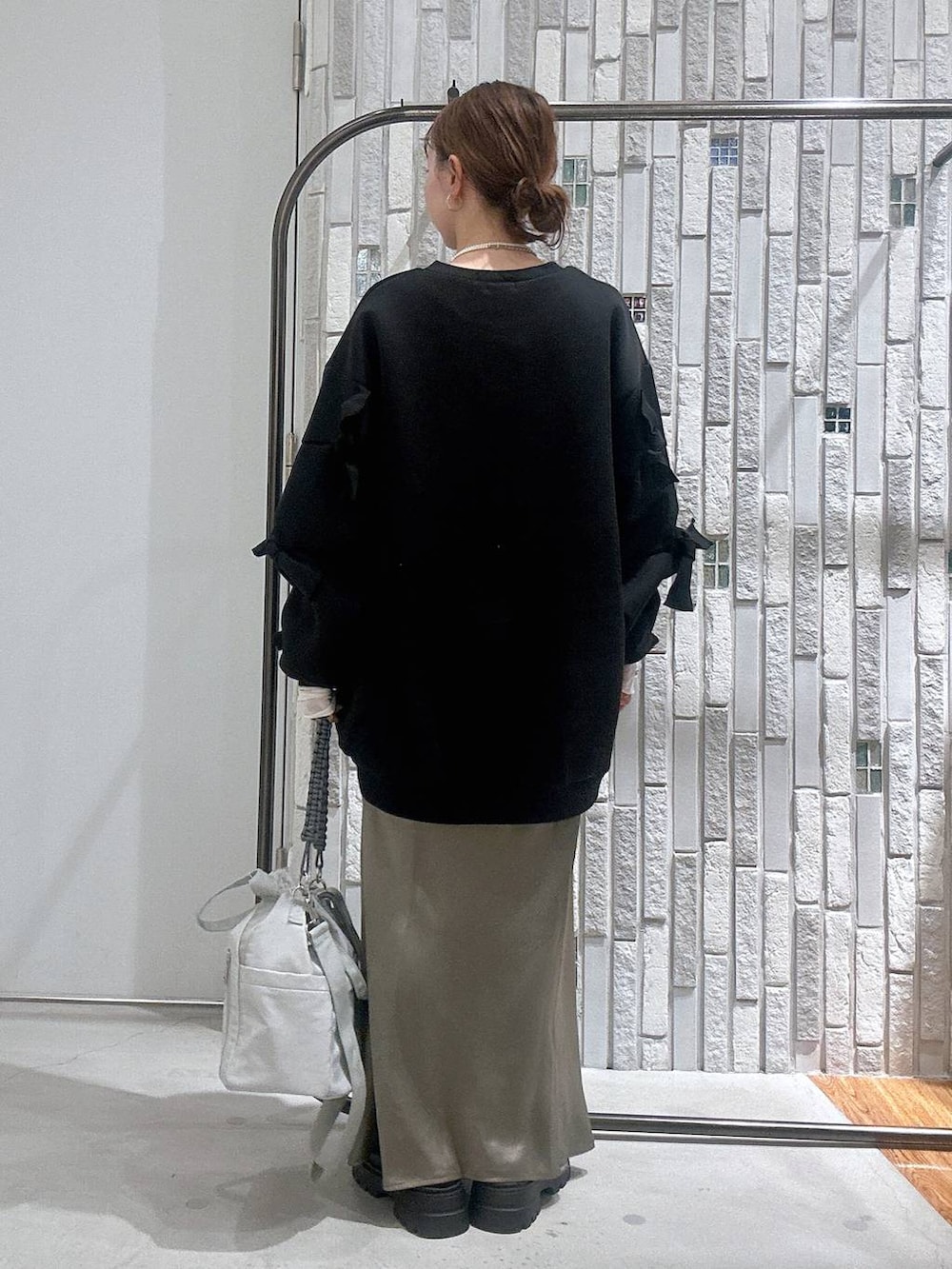 グリーン系のスカート、ブラック系のスウェット、ホワイト系のTシャツ/カットソーを着用したレディースの冬コーディネートの4枚目の写真