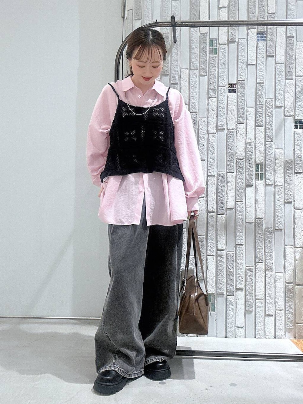 ブラウン系のボストンバッグ、グレー系のデニムパンツ、ピンク系のシャツ/ブラウスを着用したレディースの冬コーディネートの2枚目の写真