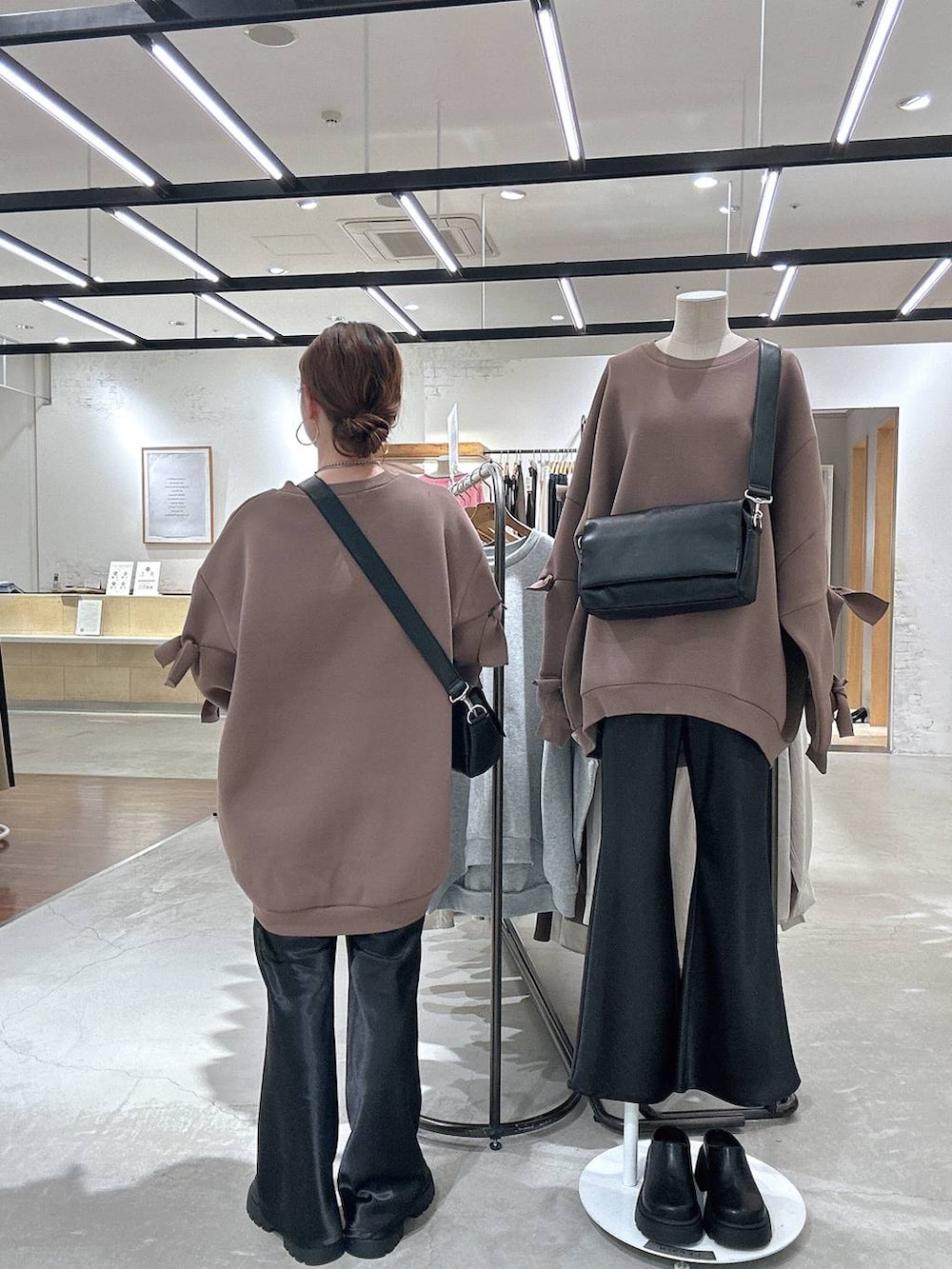 ブラック系のショルダーバッグ、ブラウン系のスウェット、ブラック系のその他シューズを着用したレディースの冬コーディネートの3枚目の写真