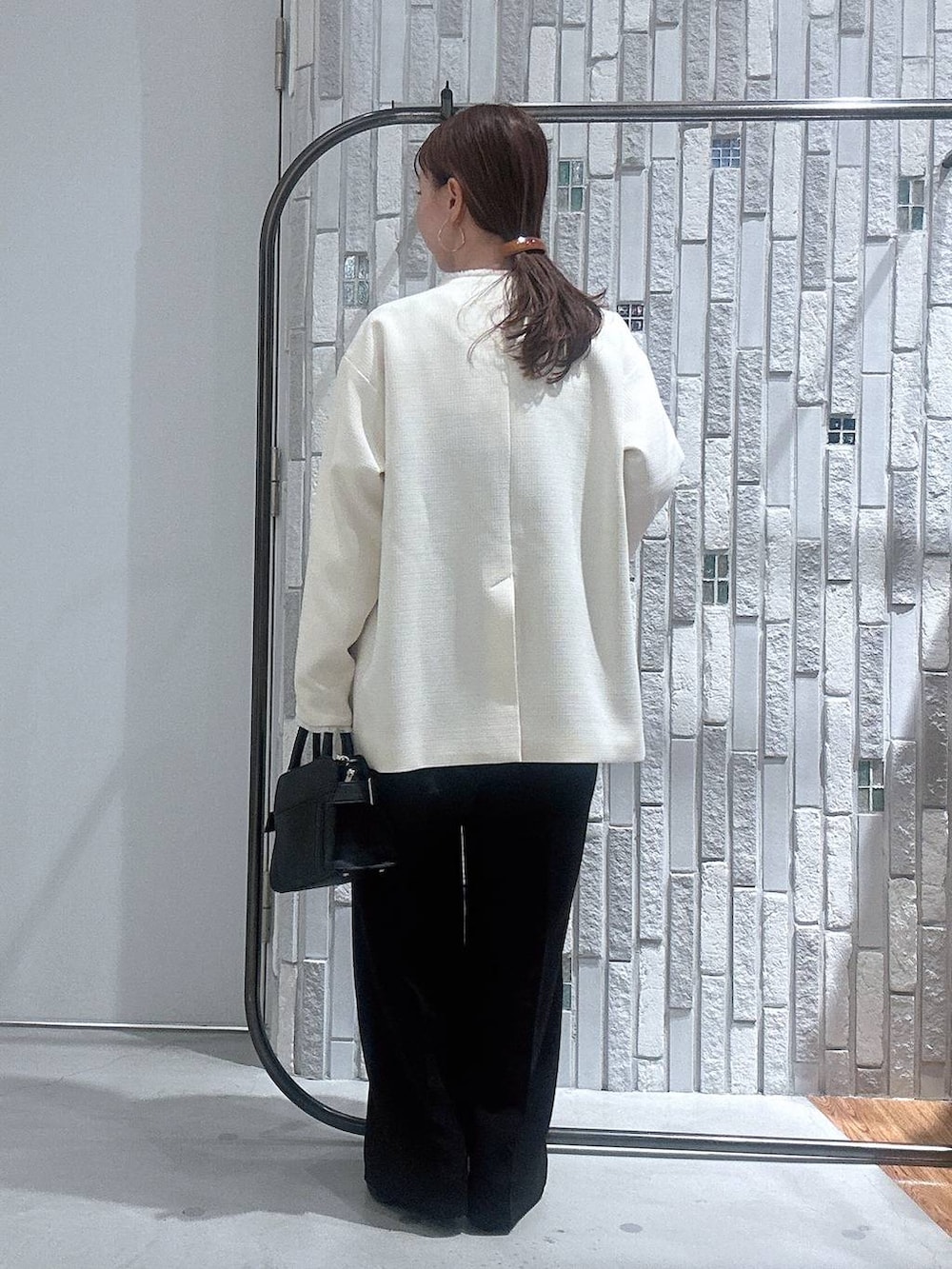 ブラック系のサロペット/オーバーオール、ホワイト系のTシャツ/カットソー、ブラック系のショルダーバッグを着用したレディースの冬コーディネートの3枚目の写真