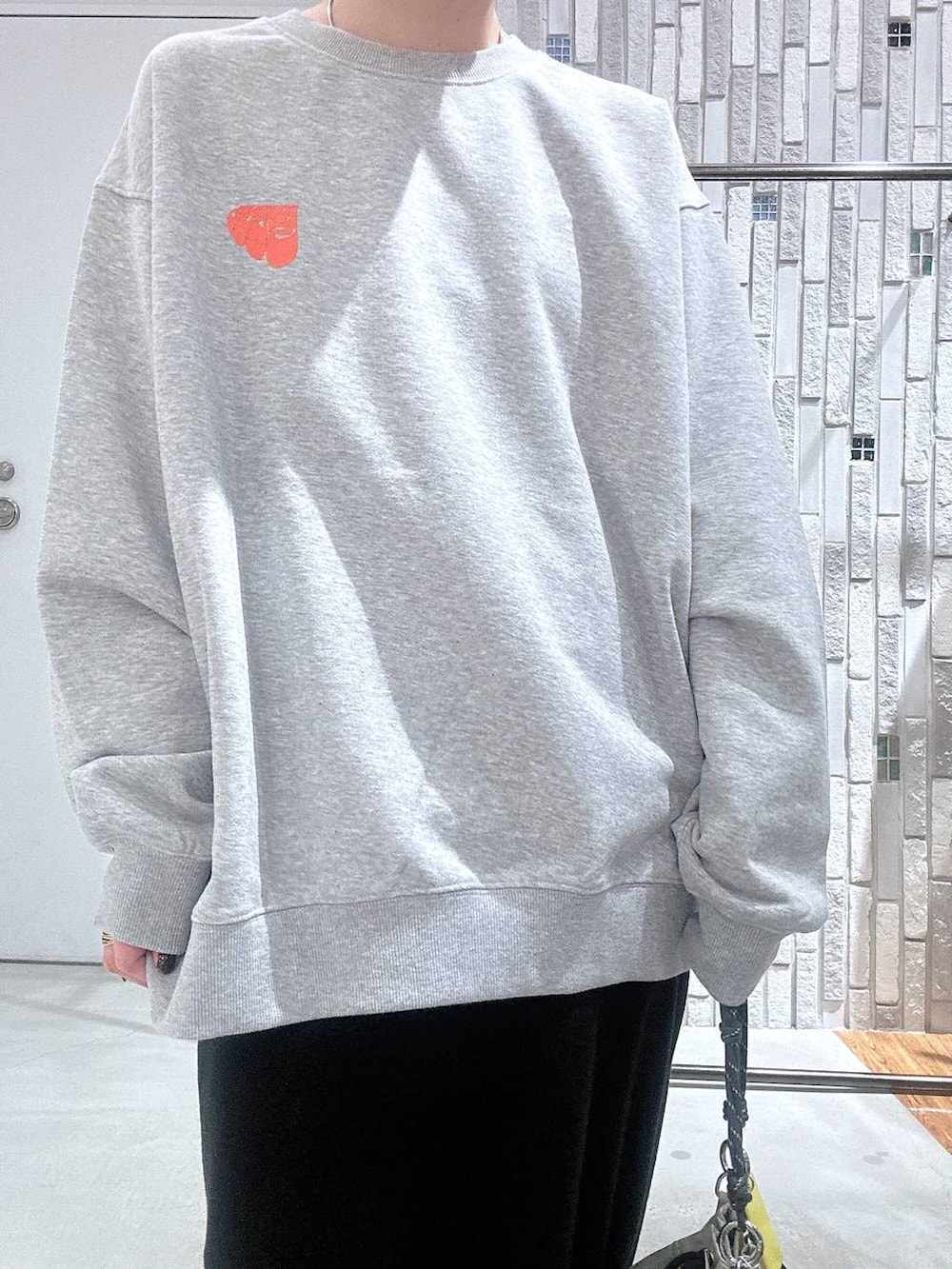 グレー系のショルダーバッグ、ブラック系のスカート、グレー系のスウェットを着用したレディースの冬コーディネートの7枚目の写真