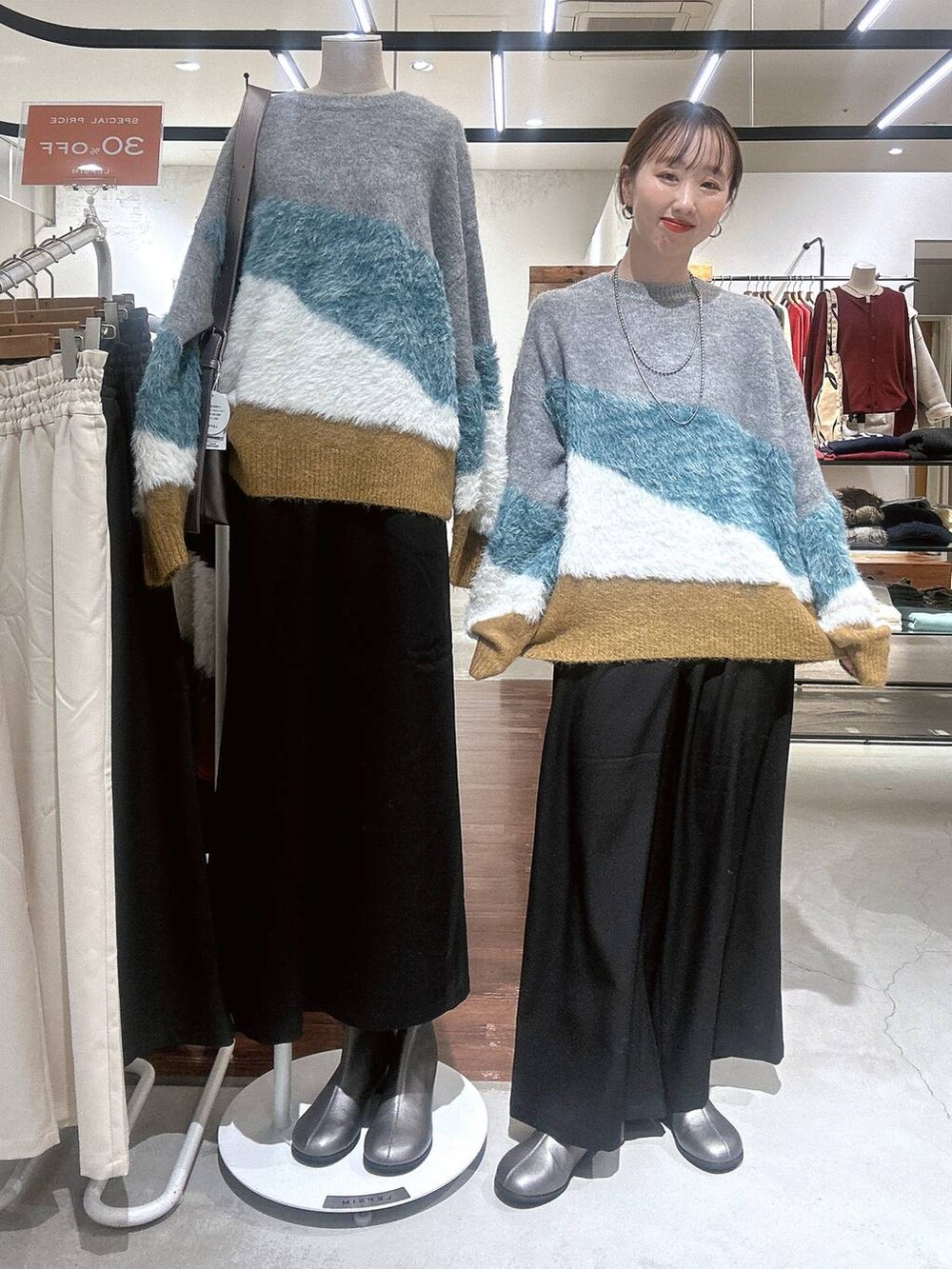 ブラック系のその他パンツ、その他のブーツ、グレー系のニット/セーターを着用したレディースの冬コーディネートの2枚目の写真