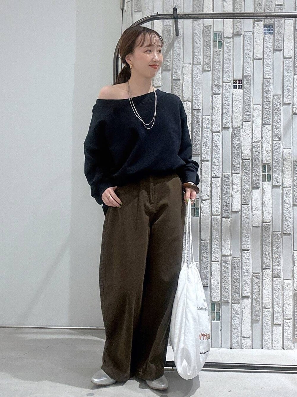 グリーン系のその他パンツ、ホワイト系のトートバッグ、シルバー系のパンプスを着用したレディースの冬コーディネートの2枚目の写真