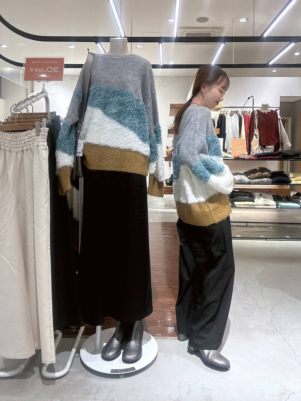 ブラック系のその他パンツ、その他のブーツ、グレー系のニット/セーターを着用したレディースの冬コーディネートの3枚目の写真