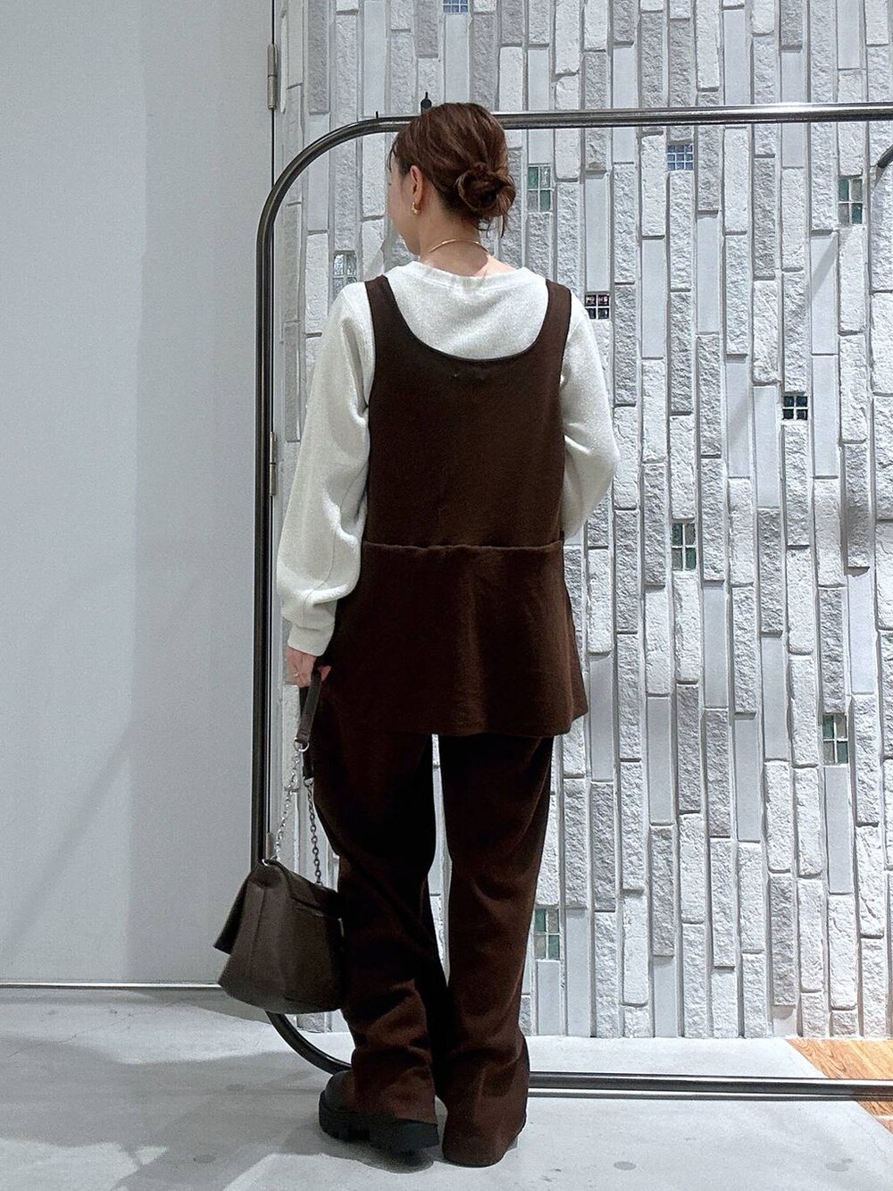 ブラック系のブーツ、ホワイト系のTシャツ/カットソー、ブラウン系のショルダーバッグを着用したレディースの冬コーディネートの5枚目の写真