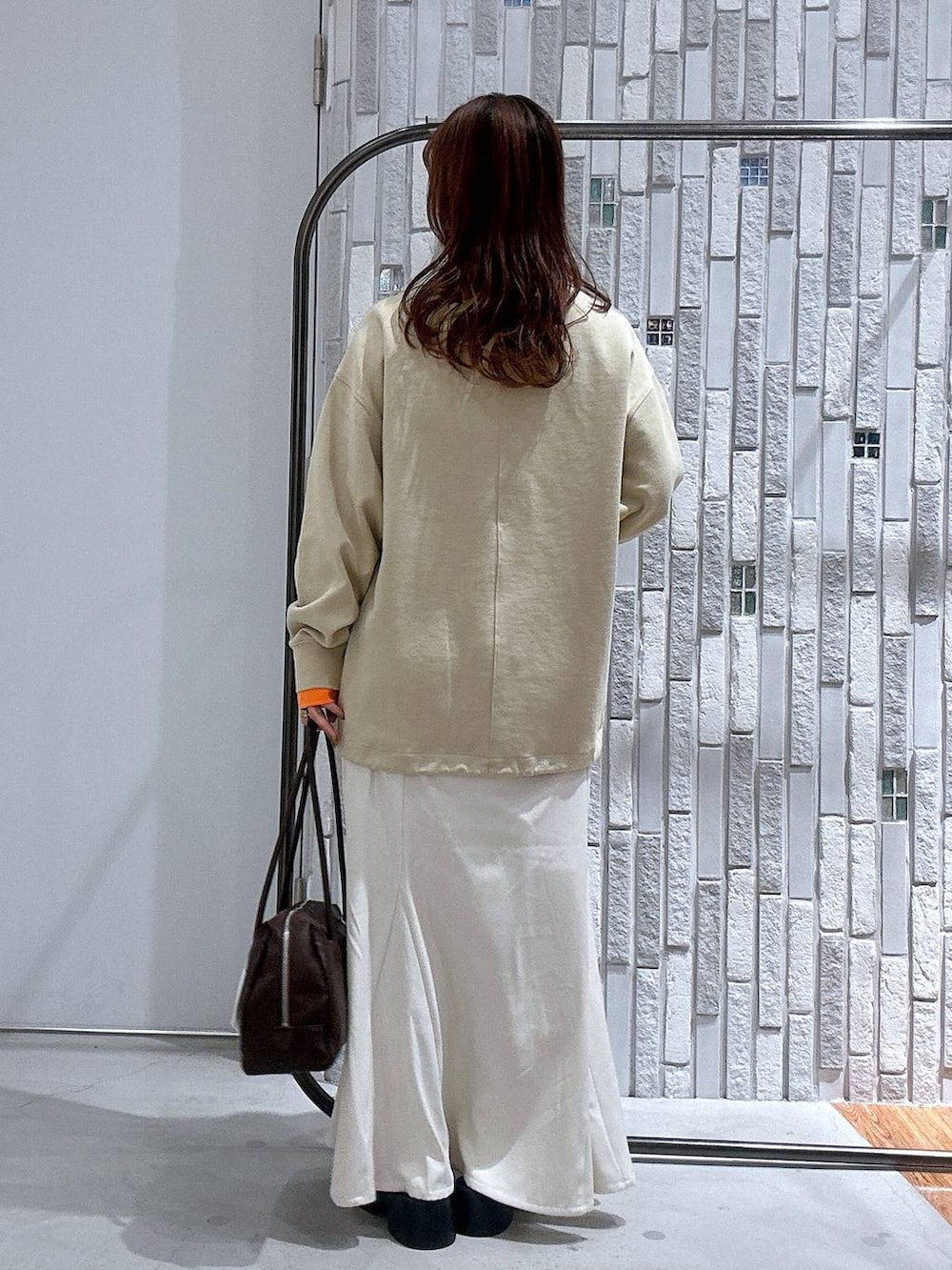 ブラック系のサンダル、ホワイト系のスカート、ブラウン系のボストンバッグを着用したレディースの冬コーディネートの4枚目の写真