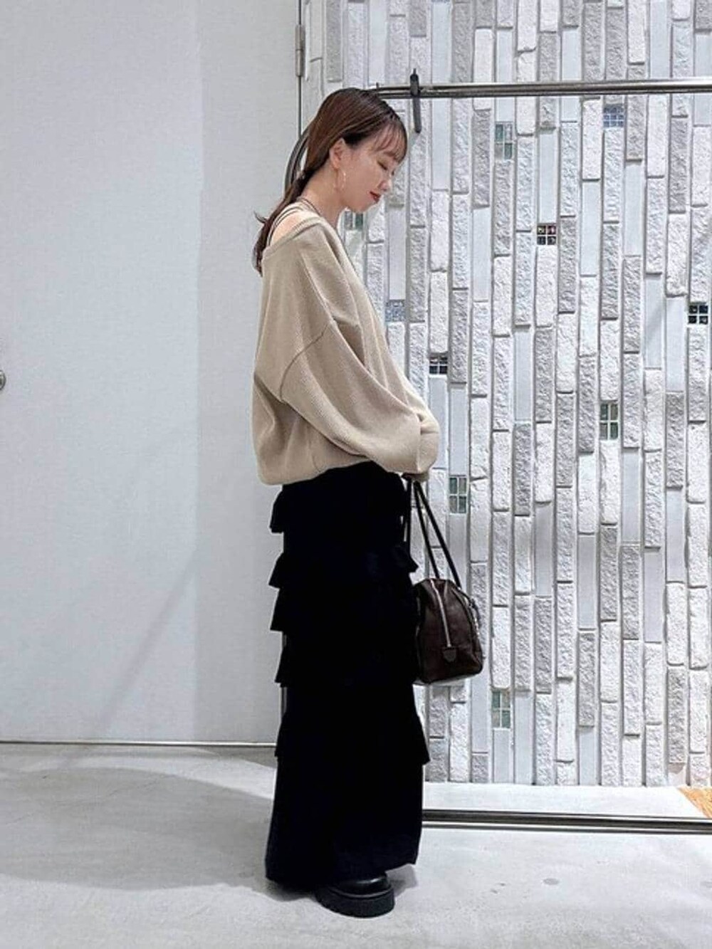 ブラウン系のボストンバッグ、ブラック系のその他シューズ、ブラック系のスカートを着用したレディースの春コーディネートの3枚目の写真