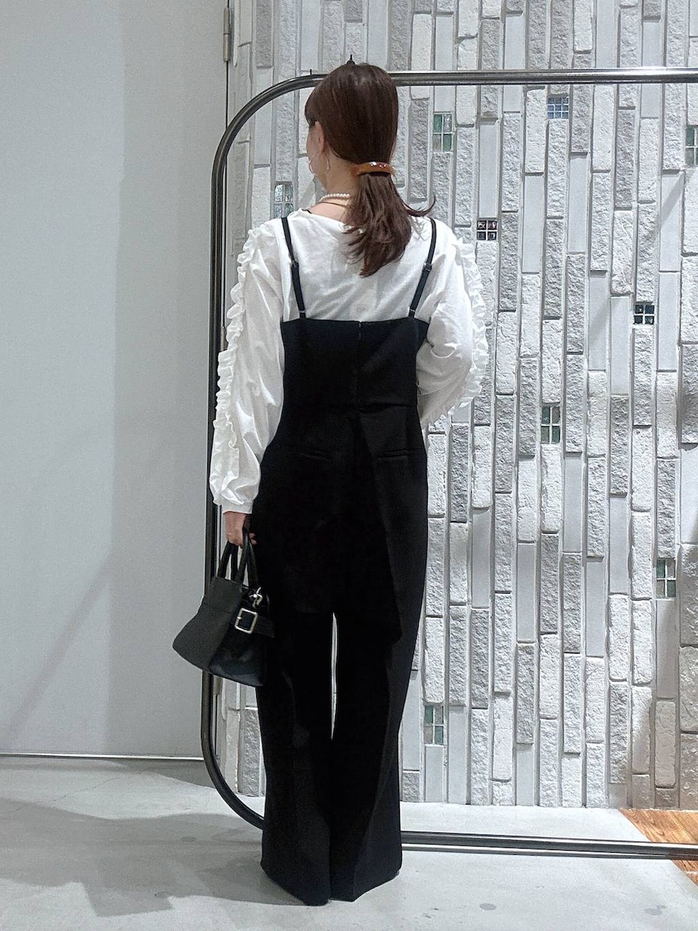 ブラック系のサロペット/オーバーオール、ホワイト系のTシャツ/カットソー、ブラック系のショルダーバッグを着用したレディースの冬コーディネートの7枚目の写真