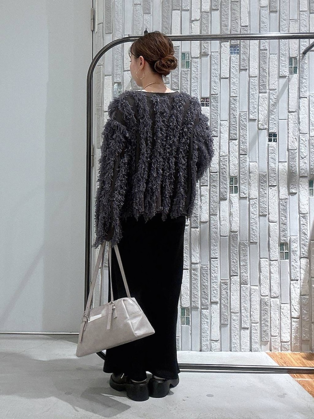 ブラウン系のサンダル、グレー系のボストンバッグ、ホワイト系のTシャツ/カットソーを着用したレディースの冬コーディネートの4枚目の写真