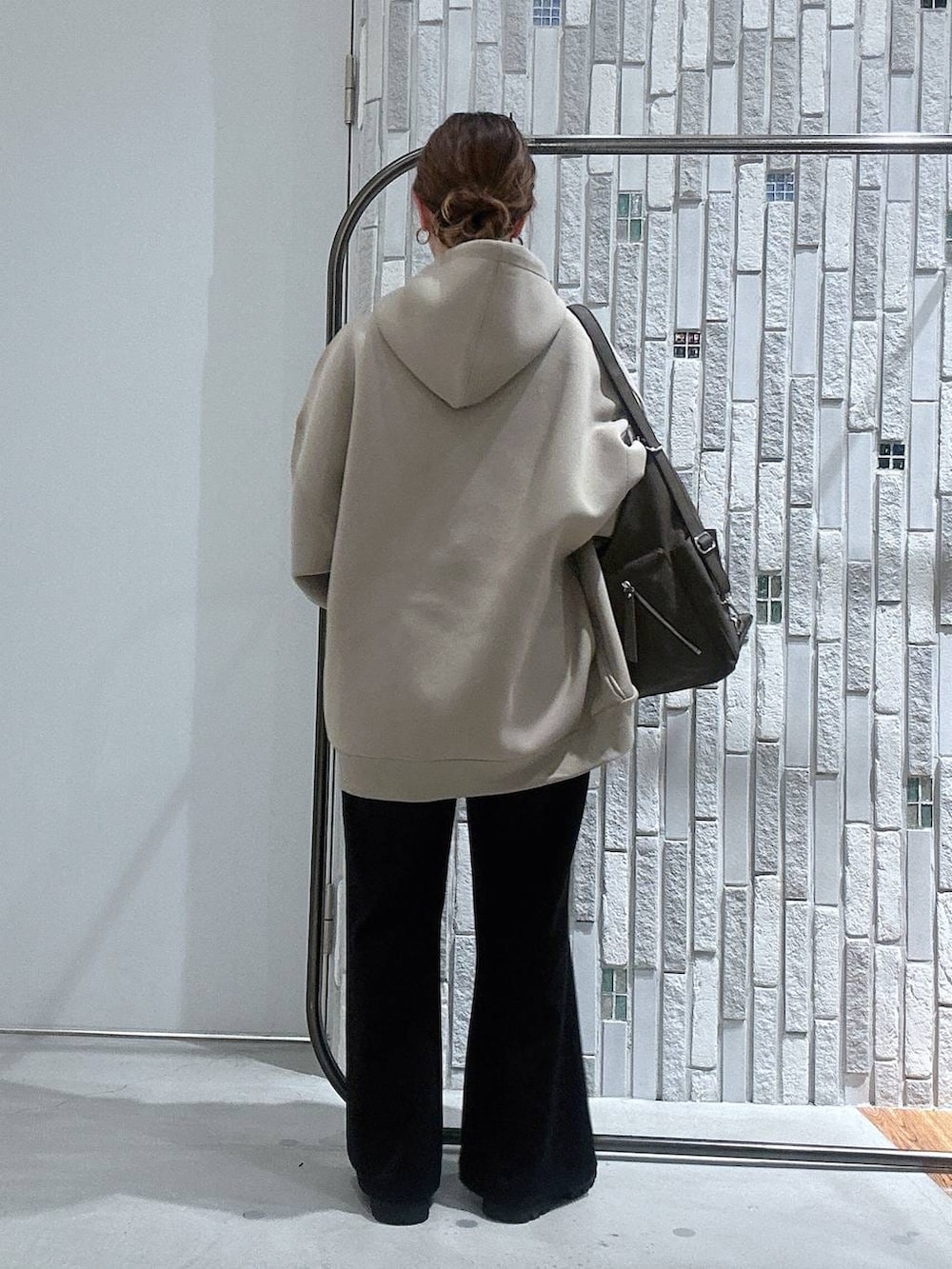 ホワイト系のTシャツ/カットソー、ベージュ系のパーカー、ブラック系のブーツを着用したレディースの冬コーディネートの3枚目の写真