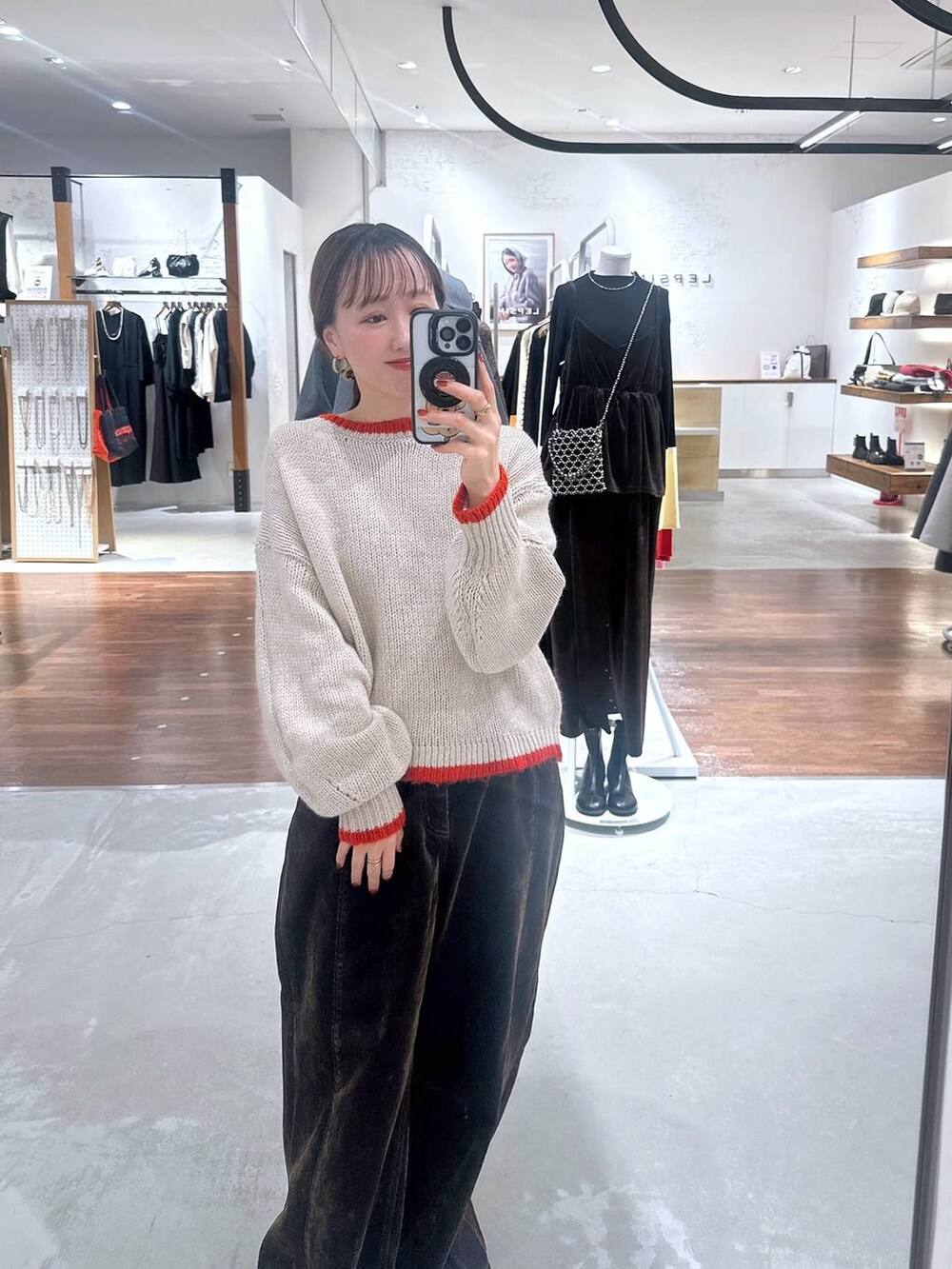 ブラウン系のデニムパンツ、ベージュ系のニット/セーターを着用したレディースの冬コーディネートの4枚目の写真