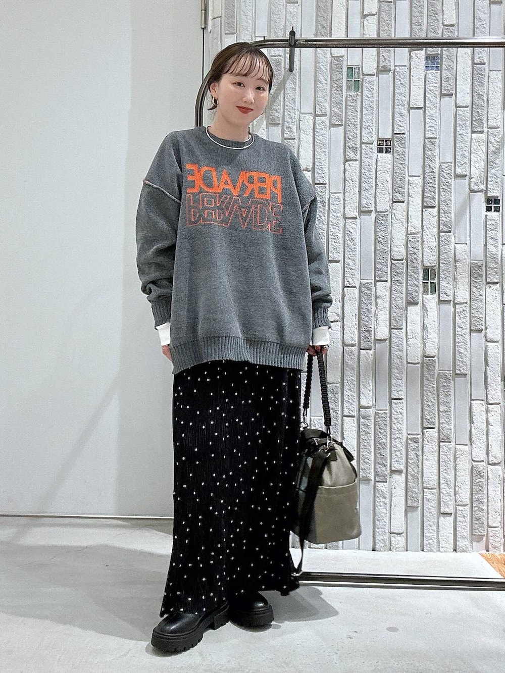 その他のスカート、ブラック系のブーツ、グレー系のニット/セーターを着用したレディースの秋コーディネートの2枚目の写真