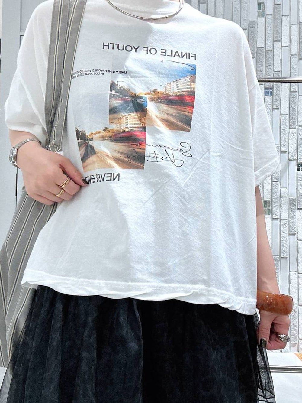 グレー系のトートバッグ、ホワイト系のTシャツ/カットソー、その他のサンダルを着用したレディースの夏コーディネートの6枚目の写真