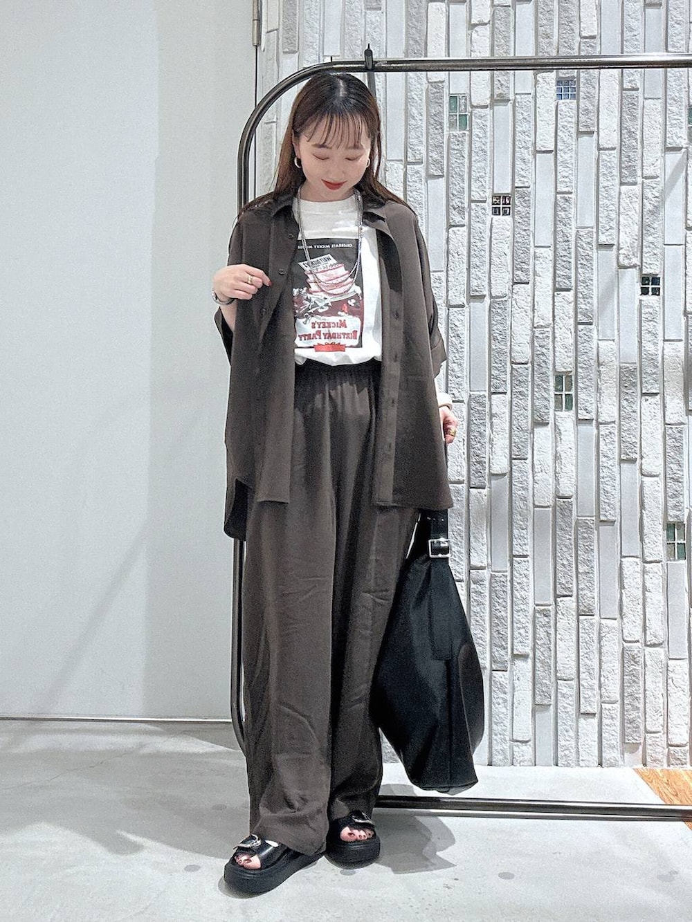 ブラウン系のその他パンツ、ブラック系のサンダル、ブラック系のショルダーバッグを着用したレディースの春コーディネートの2枚目の写真