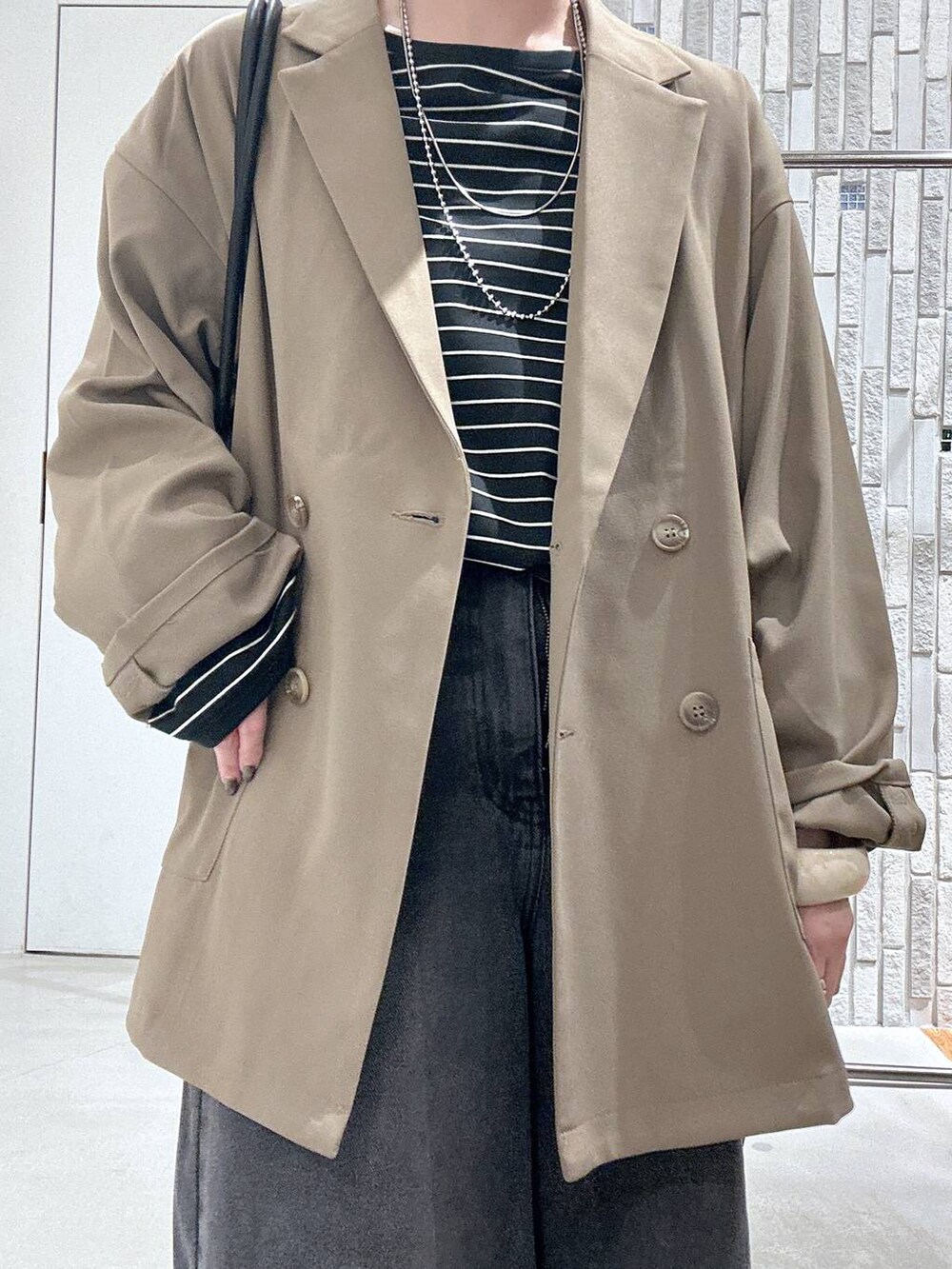 ブラウン系のテーラードジャケット、ブラック系のボストンバッグ、ブラック系のTシャツ/カットソーを着用したレディースの春コーディネートの6枚目の写真