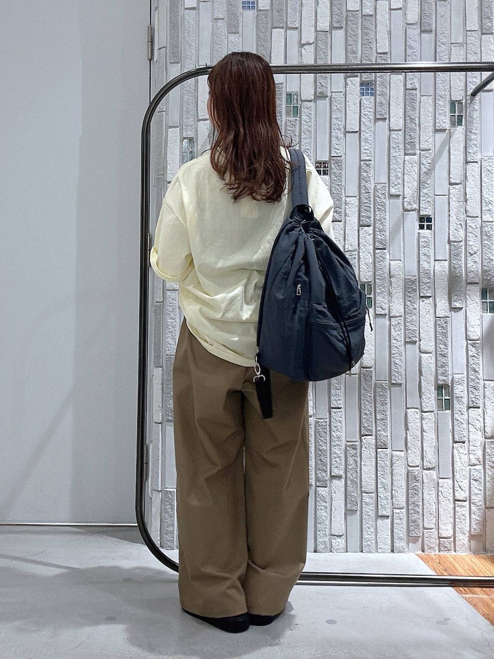 ブラック系のサンダル、グレー系のバックパック/リュック、ベージュ系のその他パンツを着用したレディースの夏コーディネートの4枚目の写真