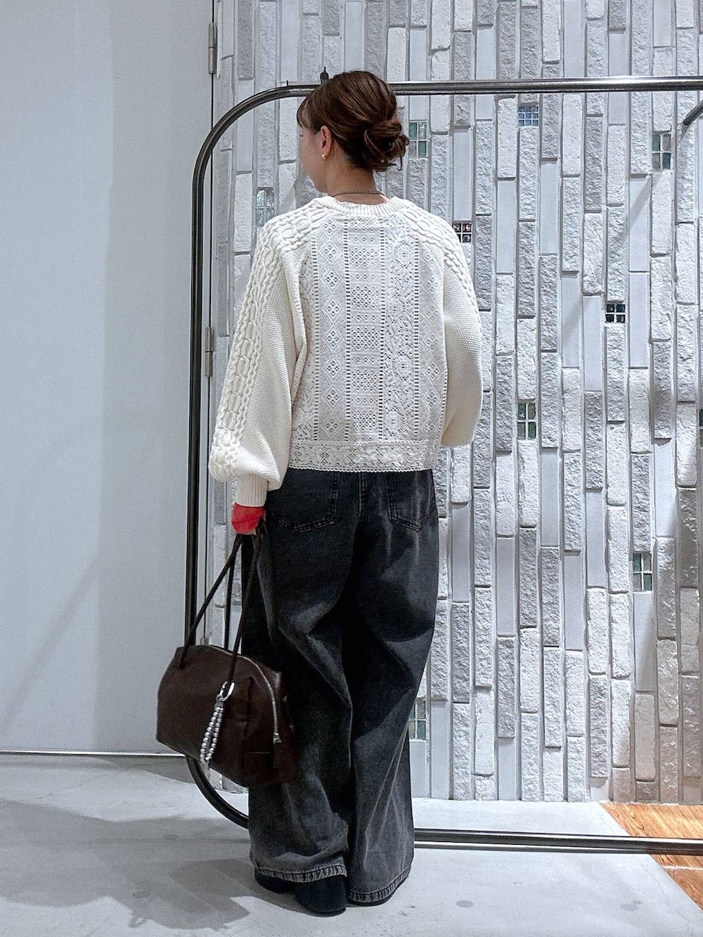 グレー系のTシャツ/カットソー、ブラウン系のサンダル、グレー系のデニムパンツを着用したレディースの冬コーディネートの4枚目の写真