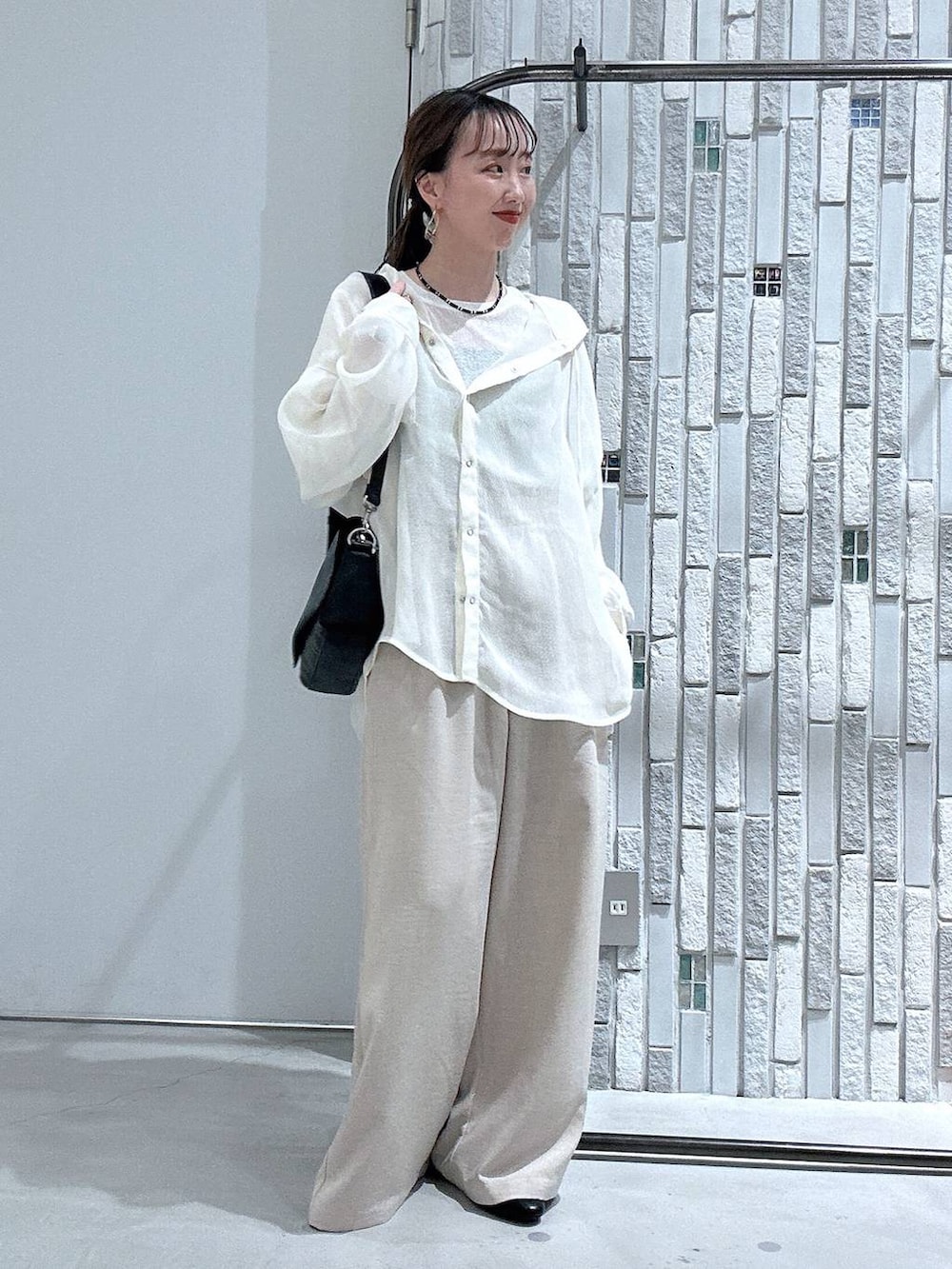 ホワイト系のTシャツ/カットソー、ブラック系のショルダーバッグ、ベージュ系のその他パンツを着用したレディースの春コーディネートの2枚目の写真