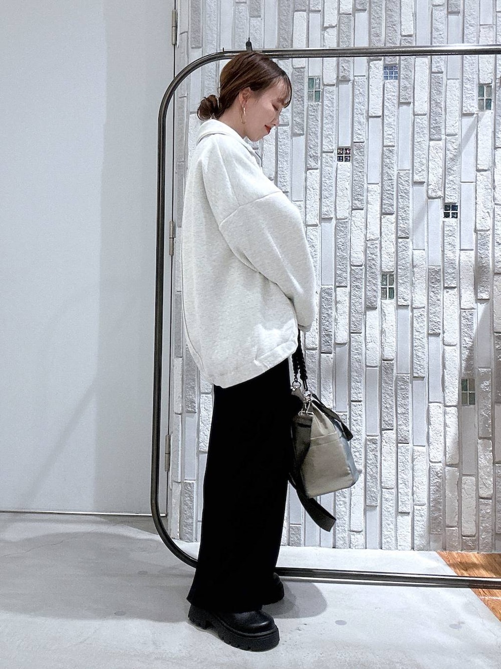 ブラック系のスカート、ブラック系のサンダル、グリーン系のショルダーバッグを着用したレディースの冬コーディネートの3枚目の写真