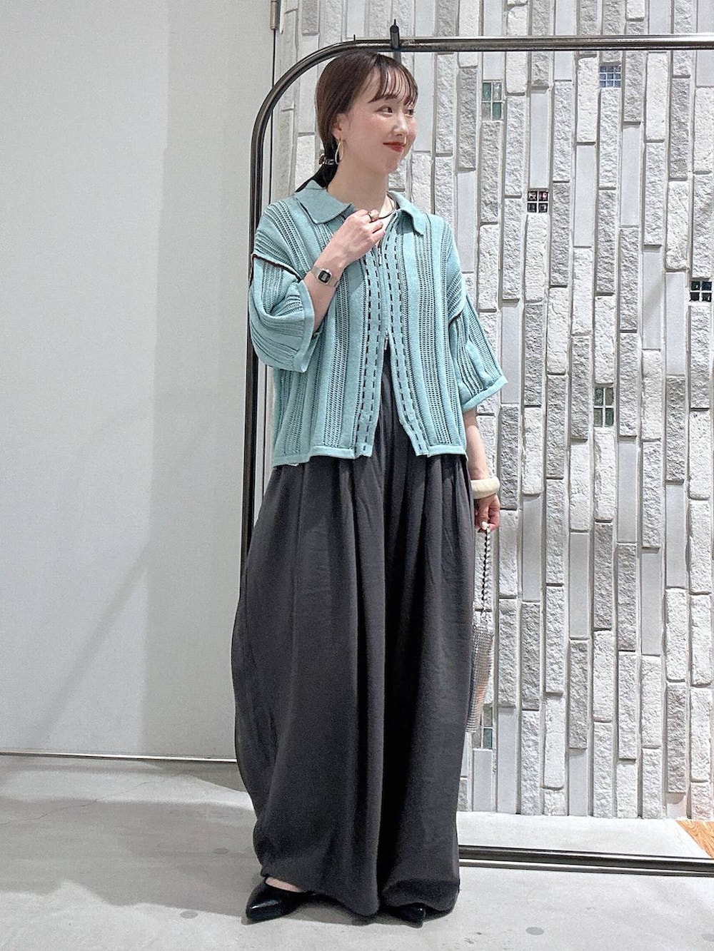 シルバー系のショルダーバッグ、ブラック系のパンプス、グレー系のその他パンツを着用したレディースの春コーディネートの3枚目の写真