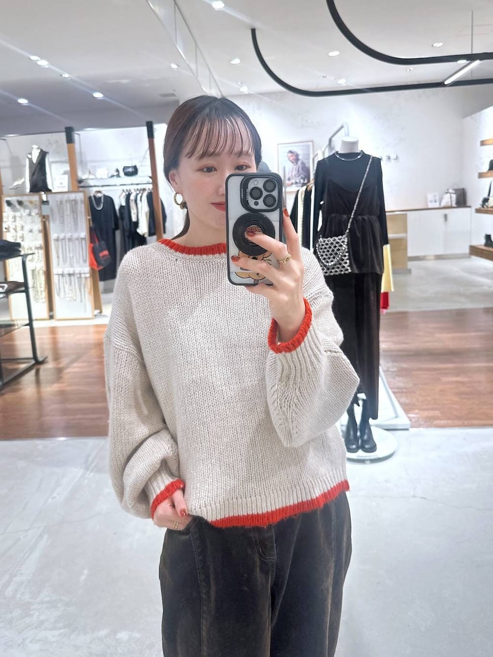 ブラウン系のデニムパンツ、ベージュ系のニット/セーターを着用したレディースの冬コーディネートの2枚目の写真