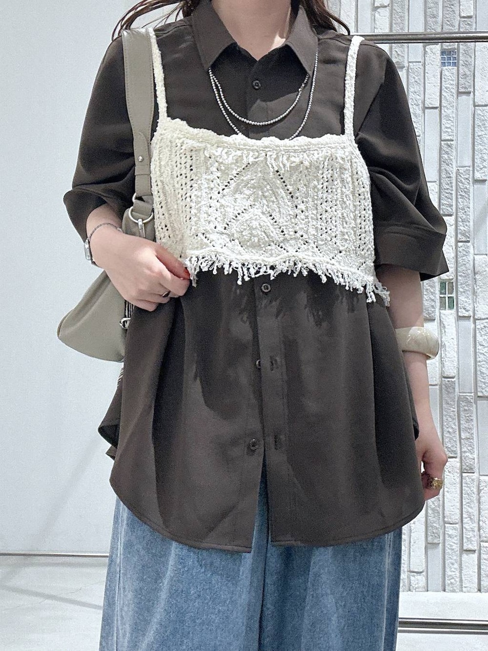 ブルー系のデニムパンツ、ブラック系のサンダル、ベージュ系のショルダーバッグを着用したレディースの春コーディネートの5枚目の写真