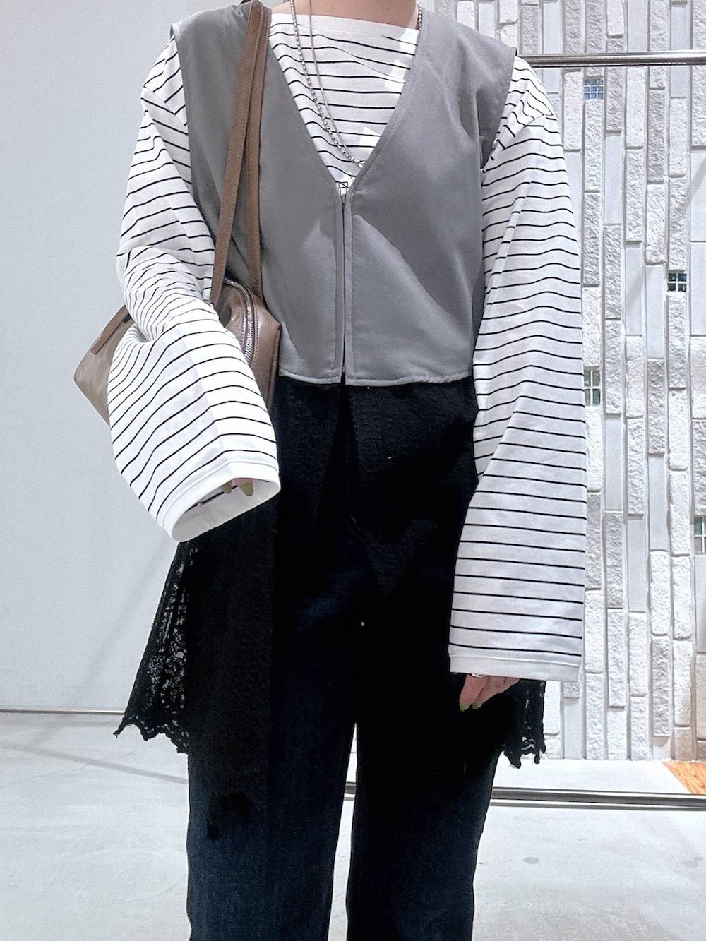 ブラウン系のボストンバッグ、ホワイト系のTシャツ/カットソー、ブルー系のデニムパンツを着用したレディースの冬コーディネートの4枚目の写真