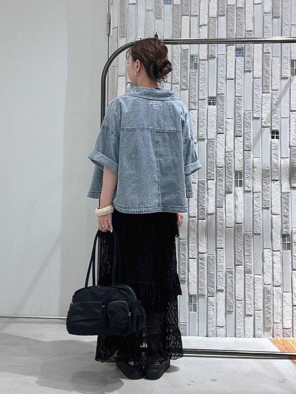 ブラック系のサンダル、ブルー系のシャツ/ブラウス、ブラック系のボストンバッグを着用したレディースの春コーディネートの4枚目の写真