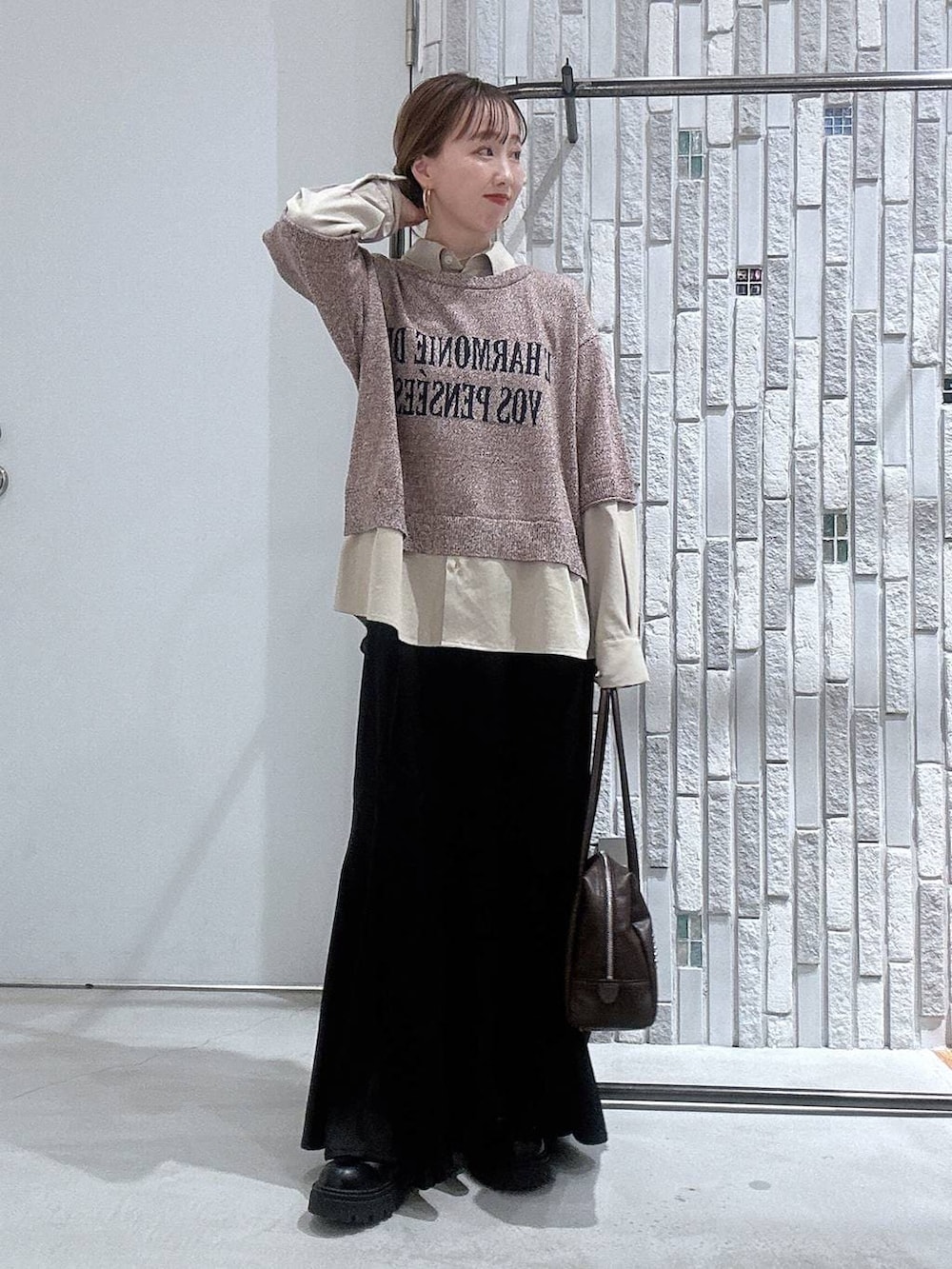 ブラック系のブーツ、ブラック系のスカート、ブラウン系のボストンバッグを着用したレディースの冬コーディネートの2枚目の写真