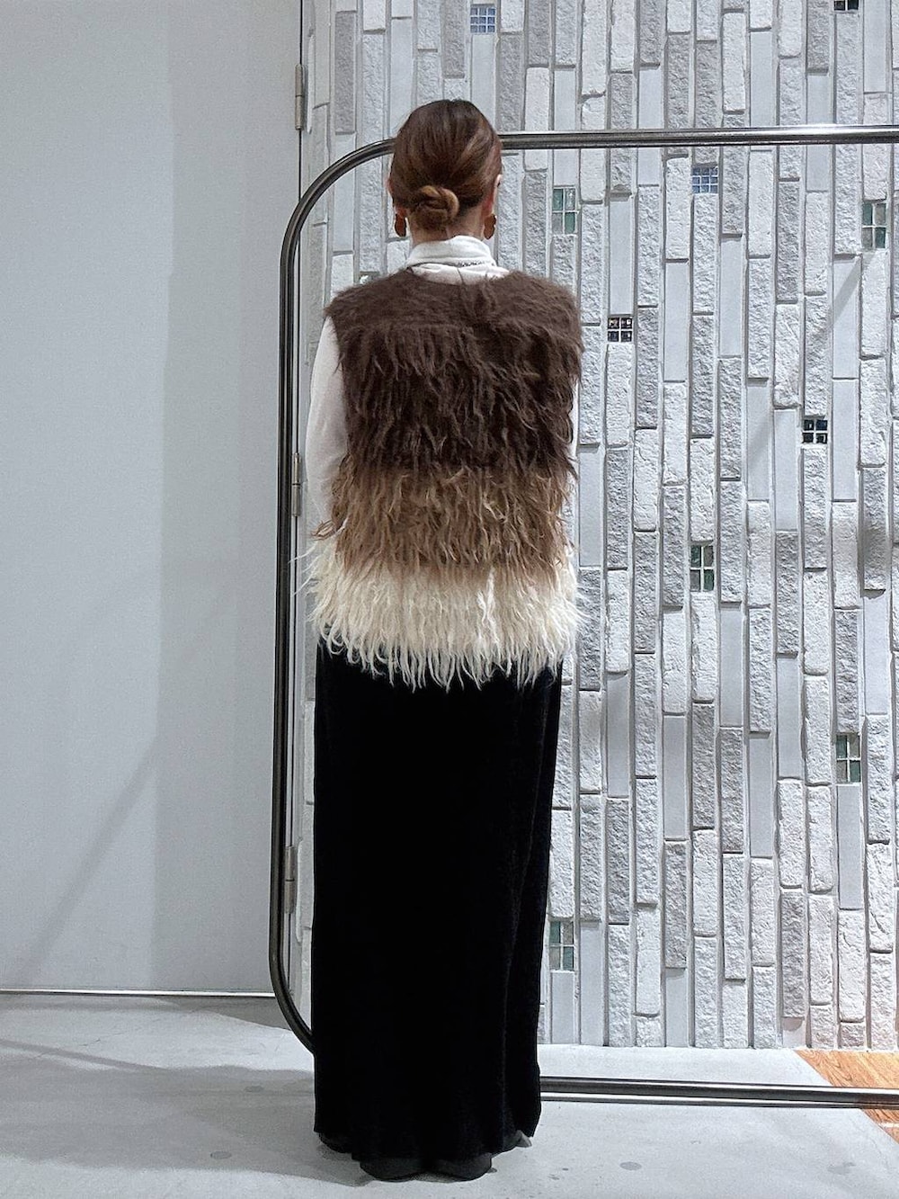 ホワイト系のTシャツ/カットソー、ブラック系のブーツ、ブラック系のスカートを着用したレディースの冬コーディネートの5枚目の写真