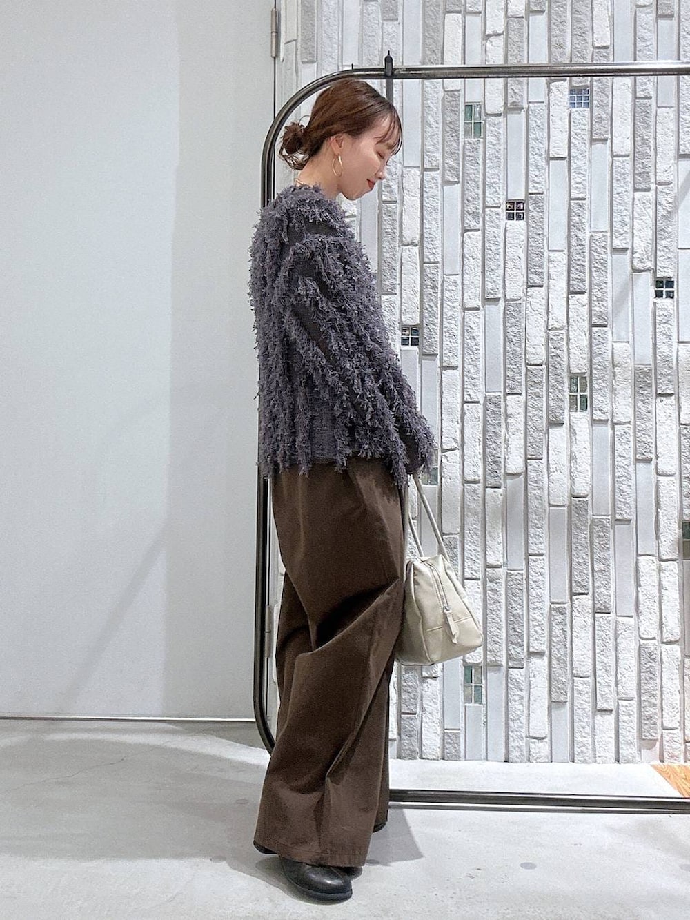 ブラック系のブーツ、ブラック系のTシャツ/カットソー、ホワイト系のボストンバッグを着用したレディースの冬コーディネートの3枚目の写真