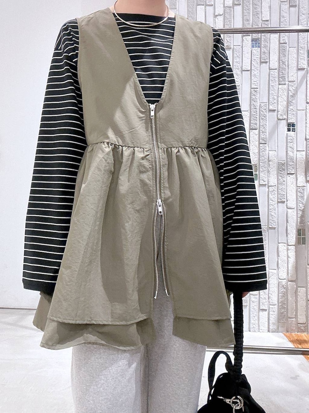 ブラック系のショルダーバッグ、ブラック系のTシャツ/カットソー、ブラック系のスニーカーを着用したレディースの冬コーディネートの4枚目の写真