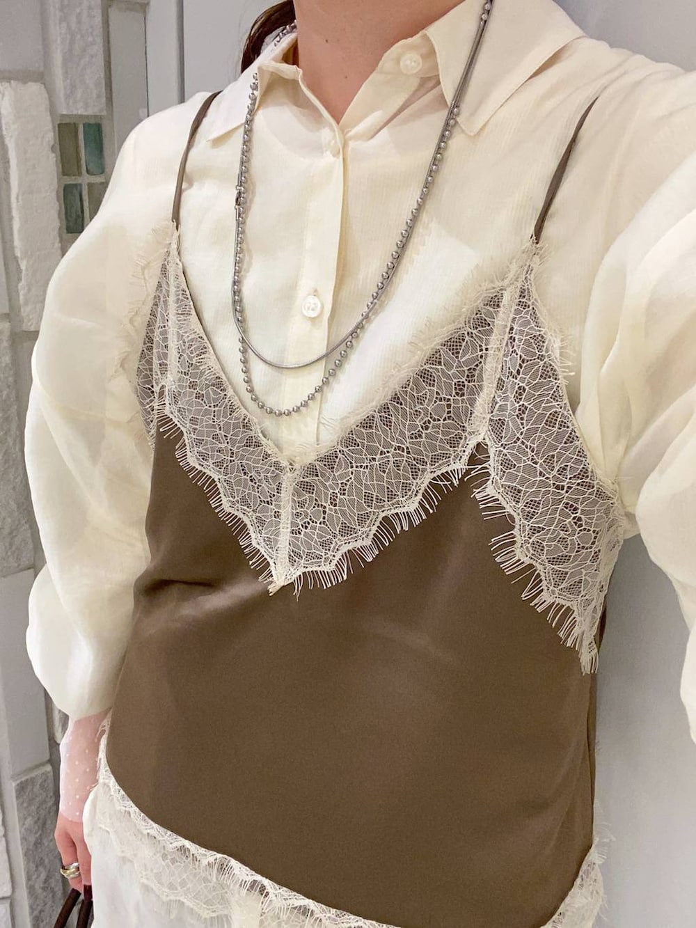 ホワイト系のシャツ/ブラウス、ホワイト系のTシャツ/カットソー、ブラウン系のボストンバッグを着用したレディースの春コーディネートの8枚目の写真