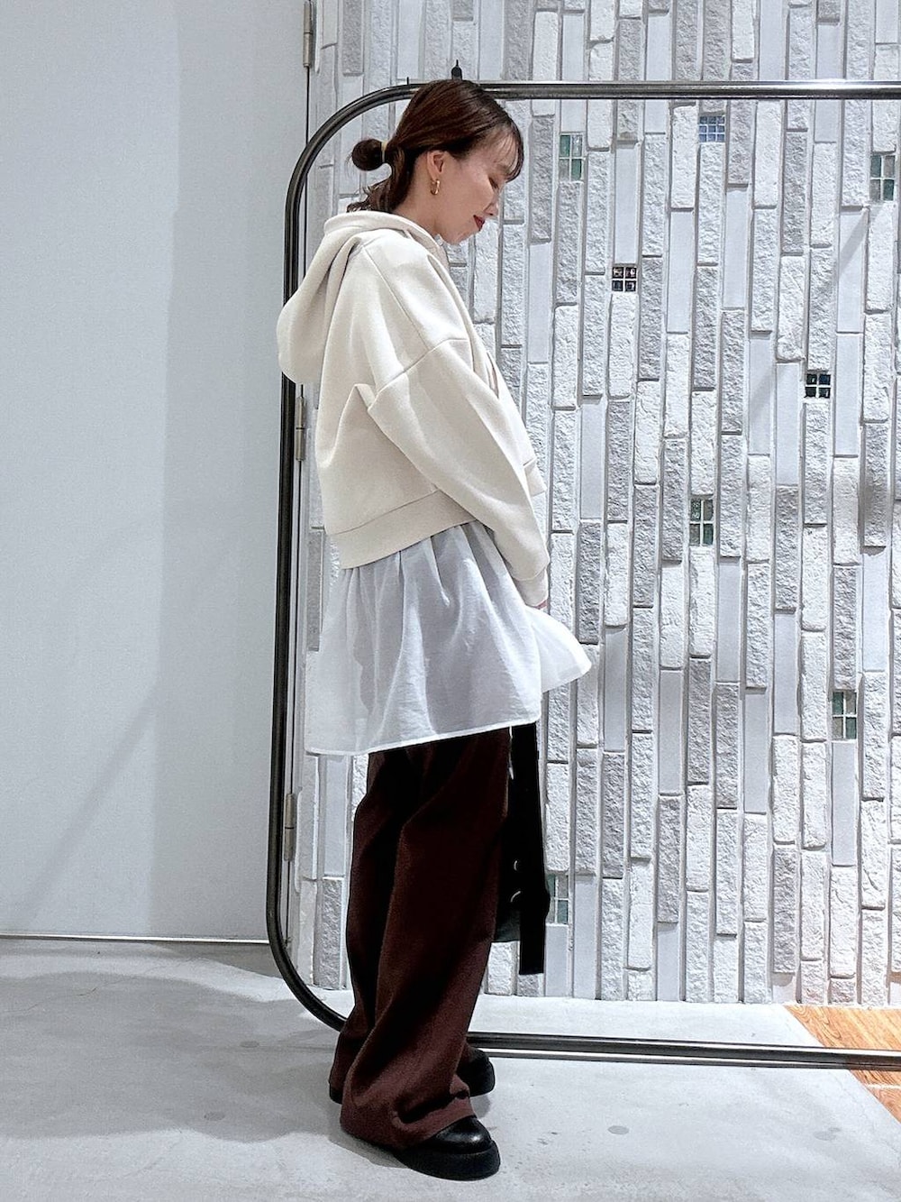 ブラック系のショルダーバッグ、ブラック系のサンダル、ホワイト系のTシャツ/カットソーを着用したレディースの冬コーディネートの3枚目の写真