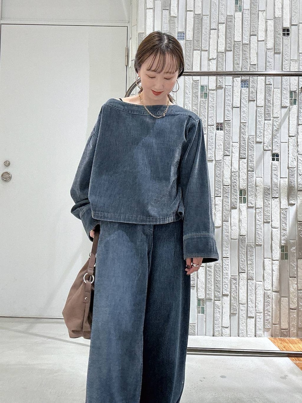 ブラック系のローファー、ブルー系のデニムパンツ、ブルー系のTシャツ/カットソーを着用したレディースの秋コーディネートの5枚目の写真