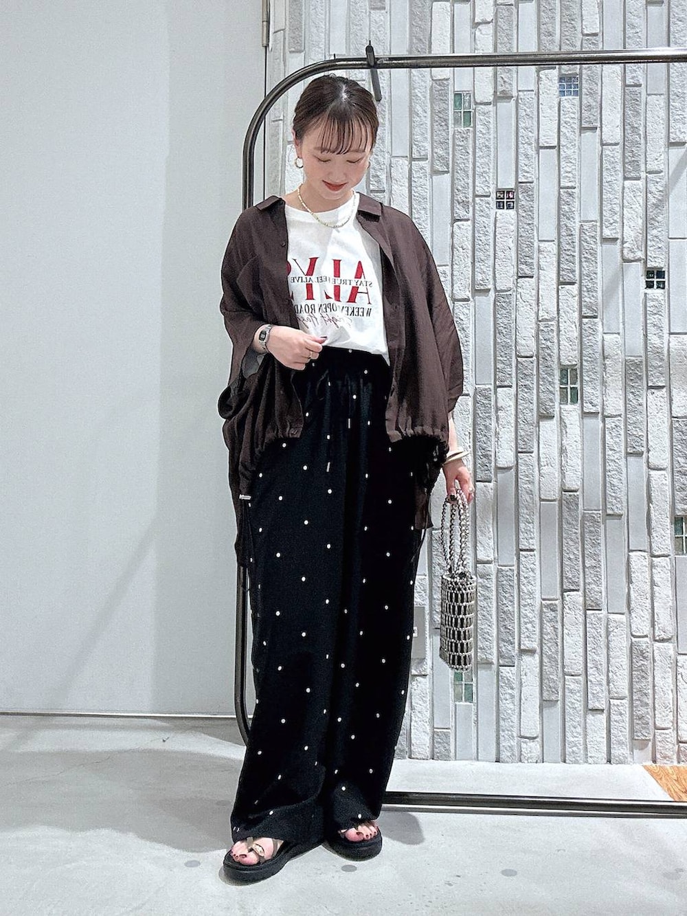ブラウン系のシャツ/ブラウス、ホワイト系のTシャツ/カットソー、ブラウン系のサンダルを着用したレディースの夏コーディネートの2枚目の写真