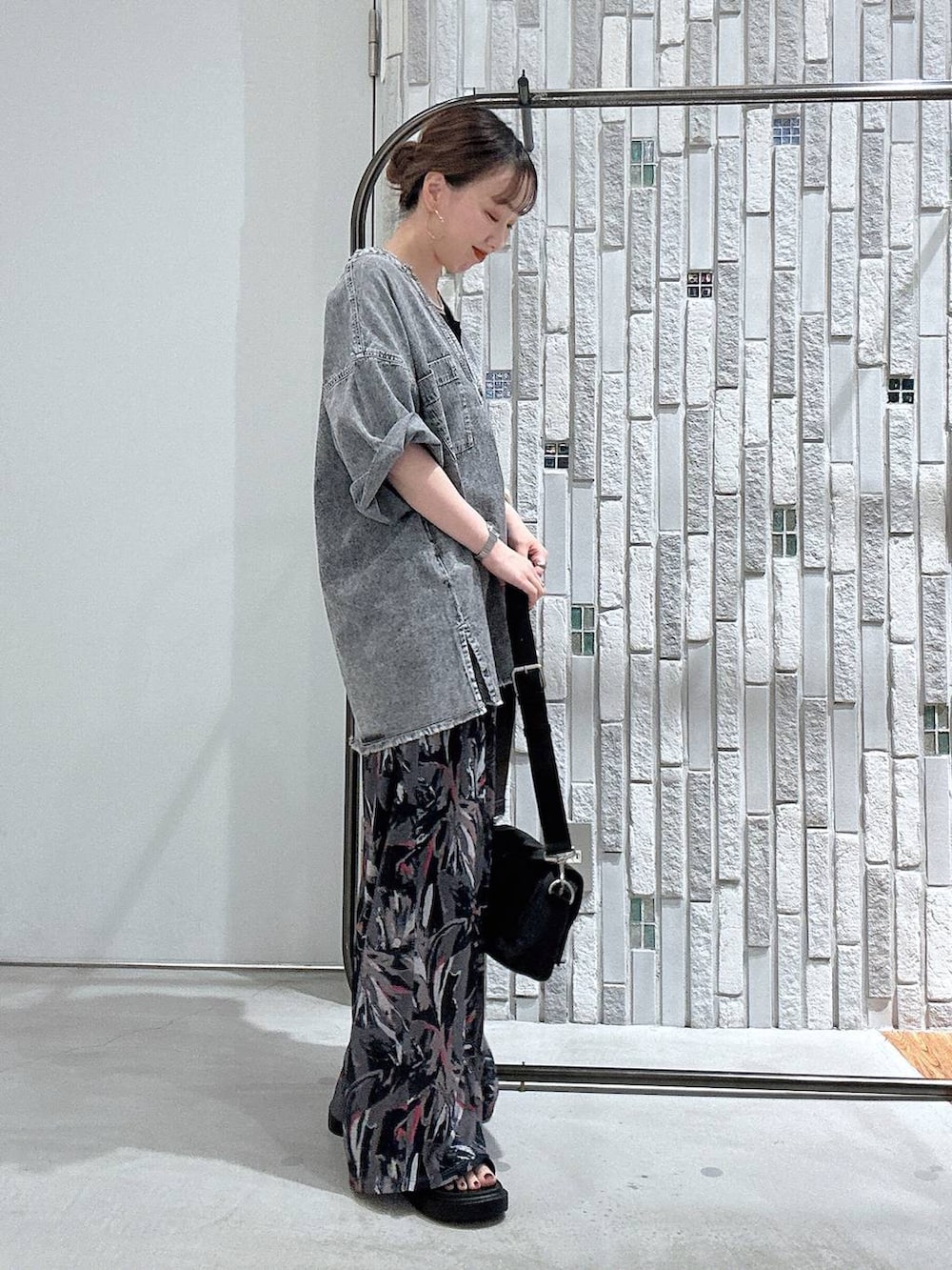 グレー系のその他パンツ、ブラック系のショルダーバッグ、ブラック系のサンダルを着用したレディースの春コーディネートの4枚目の写真
