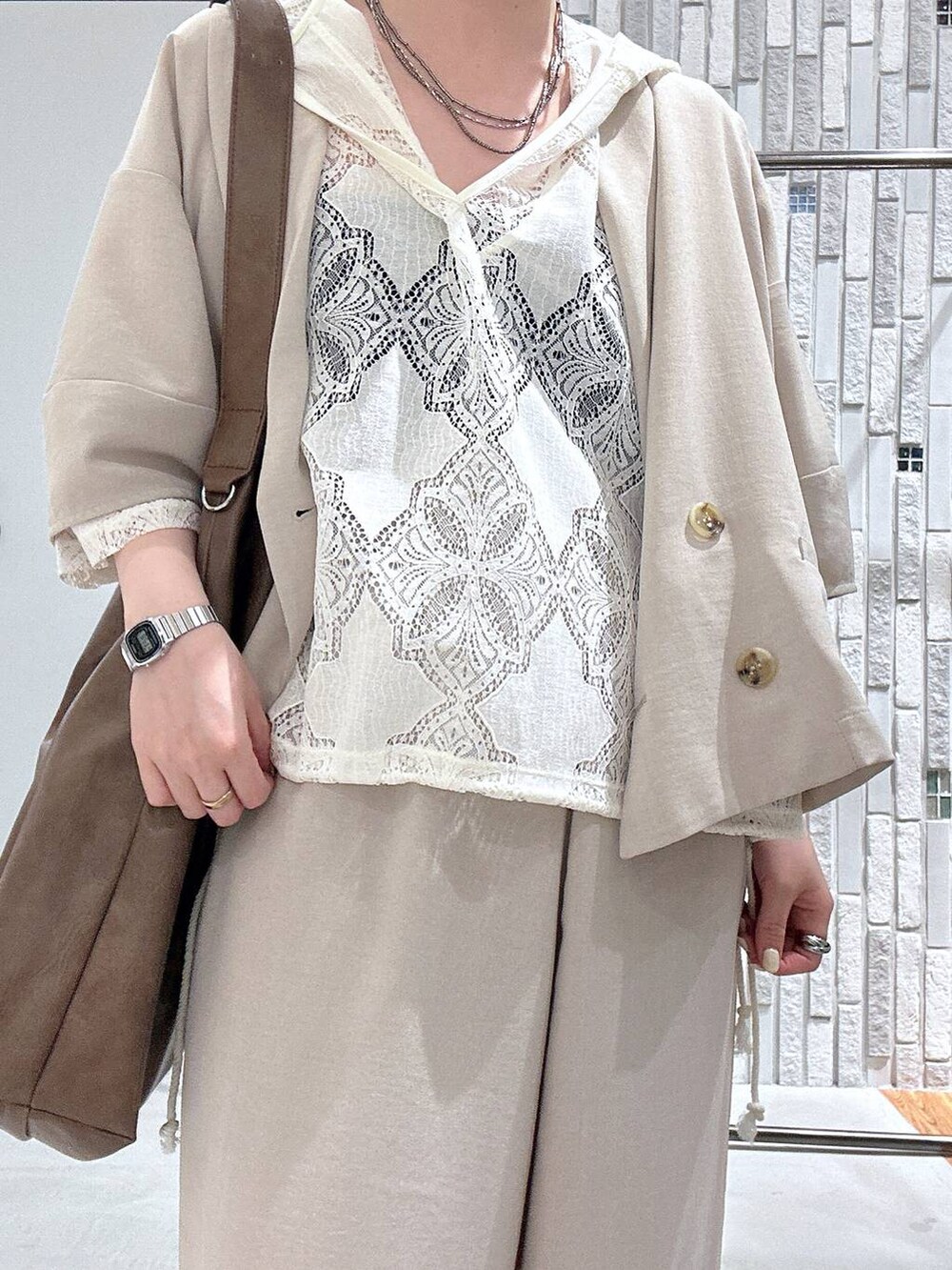 ベージュ系のその他パンツ、ベージュ系のテーラードジャケット、ブラウン系のショルダーバッグを着用したレディースの春コーディネートの5枚目の写真