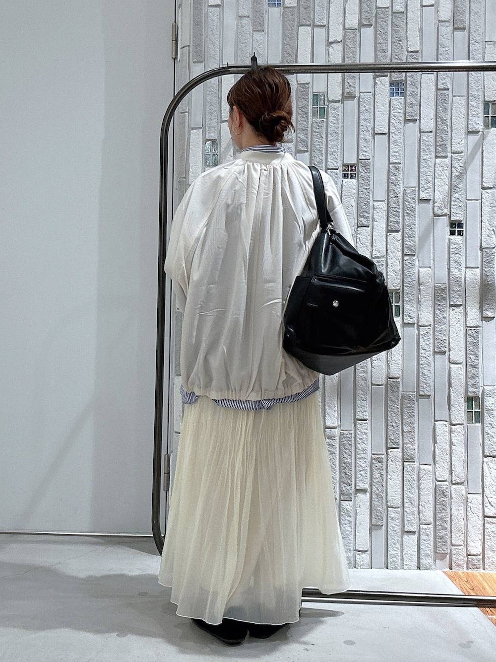 ブラック系のショルダーバッグ、ブルー系のシャツ/ブラウス、ホワイト系のブルゾンを着用したレディースの春コーディネートの5枚目の写真