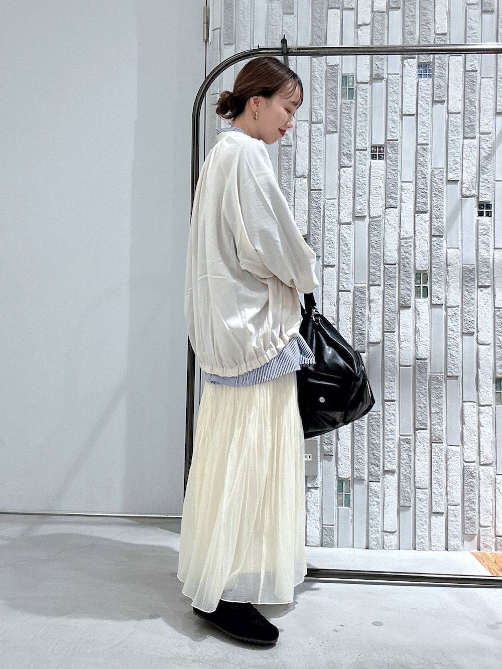 ブラック系のショルダーバッグ、ブルー系のシャツ/ブラウス、ホワイト系のブルゾンを着用したレディースの春コーディネートの4枚目の写真