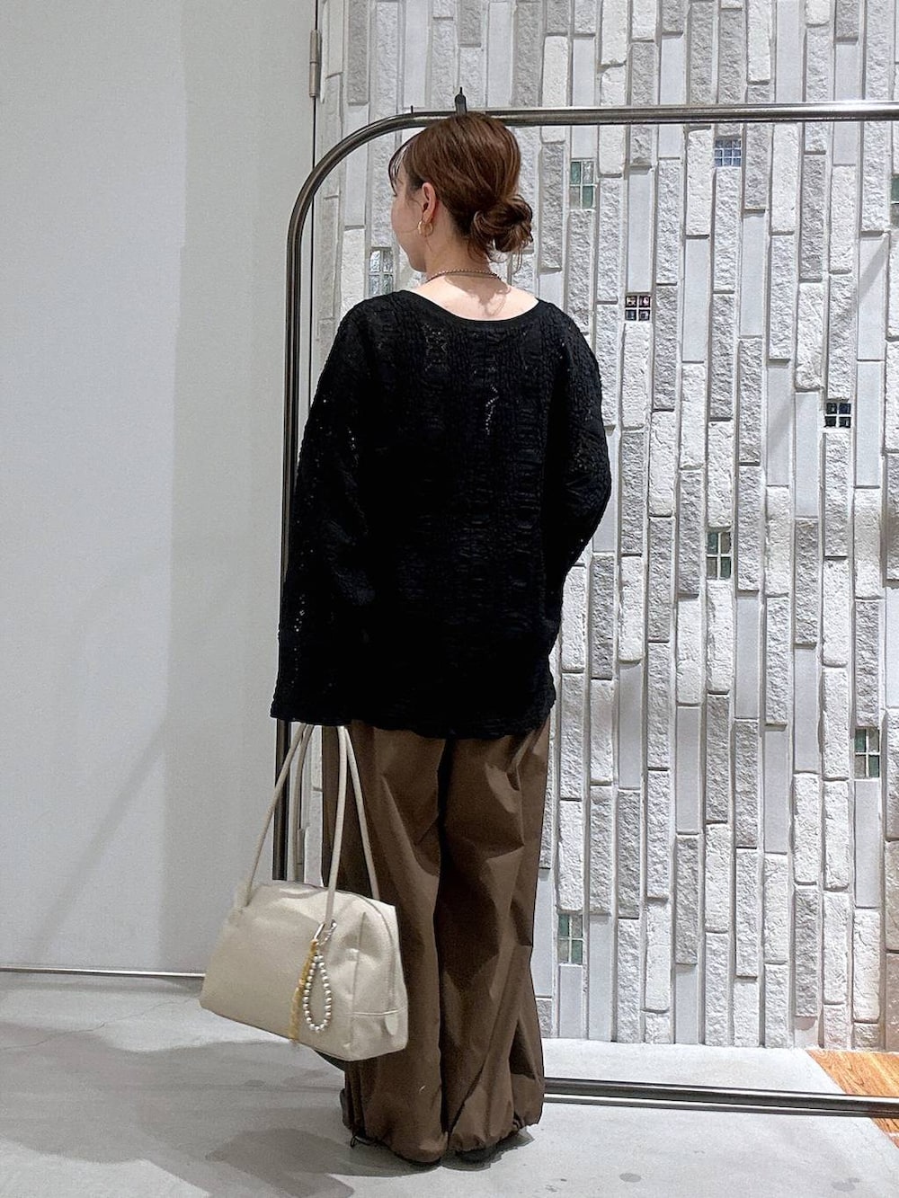 ブラウン系のその他パンツ、ホワイト系のボストンバッグ、ブラック系のTシャツ/カットソーを着用したレディースの冬コーディネートの3枚目の写真